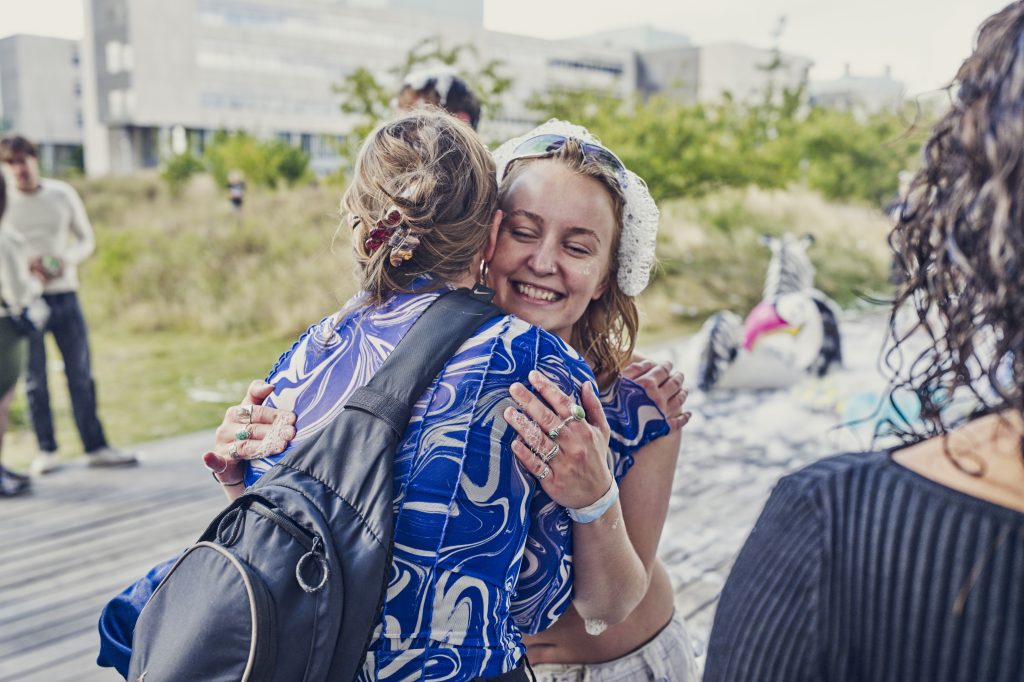 To kvinder krammer hinanden gladeligt.