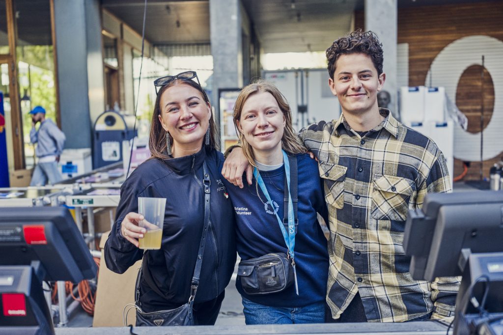 Tre personer poserer sammen udendørs.